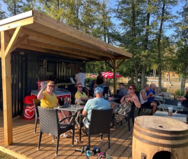 Terrasse du camping avec convives autour de tables au Gîte avec son SPA privatif