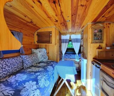 Intérieur en bois avec banquette et kitchenette dans le gite la bleuet avec piscine