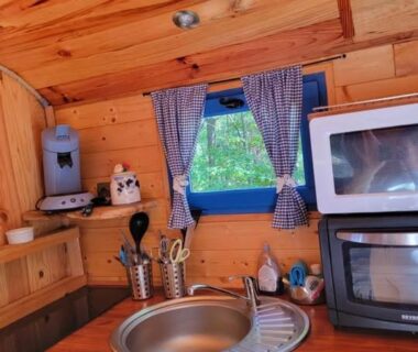 Coin cuisine en bois avec évier et micro-ondes au Gite la bleuet avec piscine