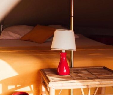 Intérieur de tente avec lampe sur table de chevet du Glamping Spot Penmarch