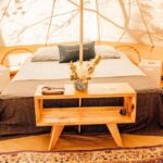 Intérieur de tente avec lit double et table basse dans le Glamping Spot Penmarch