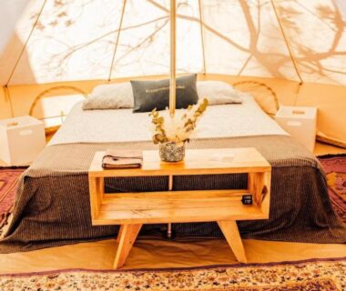 Intérieur de tente avec lit double et table basse dans le Glamping Spot Penmarch
