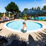 Bassin circulaire devant piscine couverte et transats au Glamping Terre & Mer