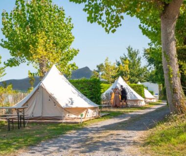 Allée herbeuse et tentes glamping sous les arbres au Glamping Urrugne