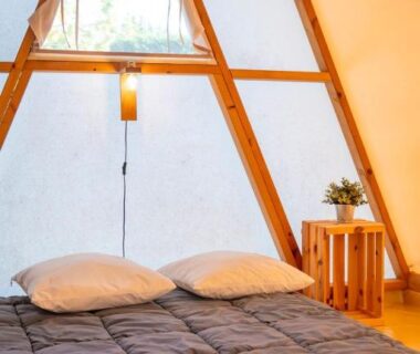 Intérieur de tente avec lit chapeau et table en bois dans le Glamping Urrugne