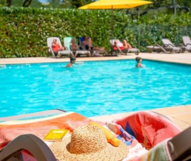 Piscine extérieure avec transats parasol et chapeau sur serviette au Glamping Urrugne