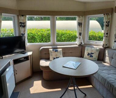Séjour intérieur avec banquette table télévision dans le mobil-home Glenan01
