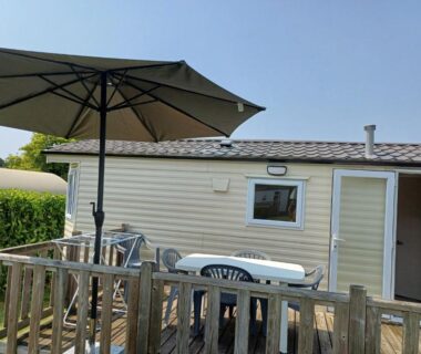 Terrasse avec table chaises et parasol du mobil-home Glenan01