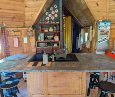 Intérieur de cuisine en bois avec plan de travail central dans Graines de nature Ecolodges Insolites