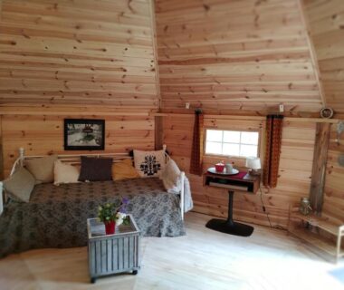 Intérieur en bois avec banquette et petite fenêtre dans Graines de nature Ecolodges Insolites