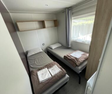 Chambre avec deux lits simples et serviettes dans le Grand MobilHome