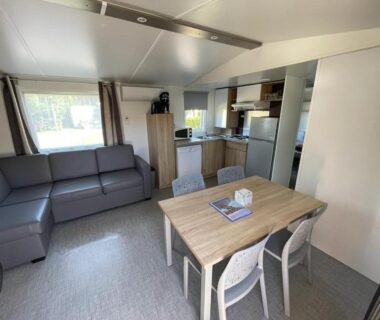 Intérieur avec coin repas table et canapé du Grand MobilHome