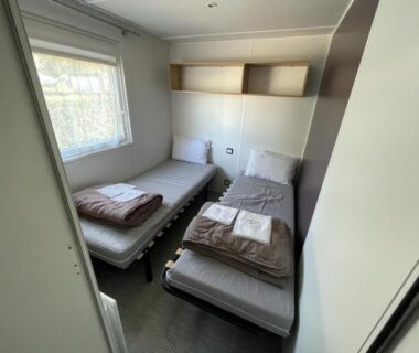 Chambre avec deux lits simples et serviettes dans le Grand MobilHome
