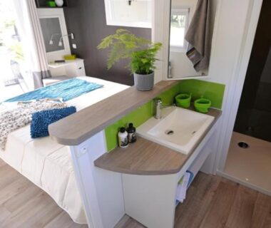 Intérieur avec kitchenette et lit dans le Grand Mobile home Taos 2 chambres 2 salles d'eau