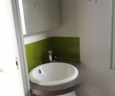 Salle d'eau avec lavabo rond et miroir dans le Grand Mobile home Taos