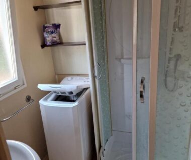 Salle d'eau avec cabine de douche et lave-linge du Grand Mobile home dans camping