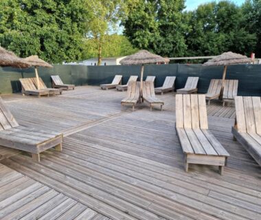 Terrasse en bois avec transats et parasols au Grand Mobile home dans camping