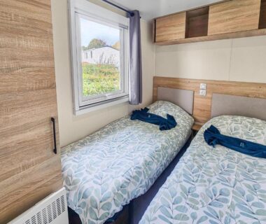 Chambre avec deux lits et fenêtre dans le mobilhome Green harmony