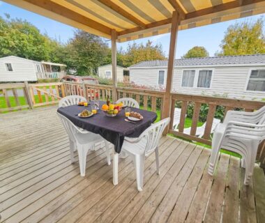 Terrasse en bois avec table et chaises et mobil homes en arrière plan au Green harmony