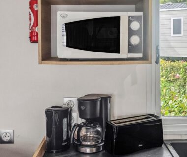 Coin cuisine avec micro-ondes cafetière et grille-pain dans le mobil-home Green harmony