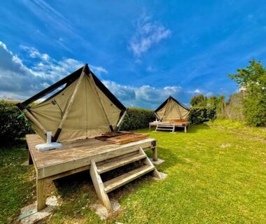 Plateforme en bois avec tentes glamping sur pelouse au Hébergement bord de mer MERVILLE FRANCEVILLE