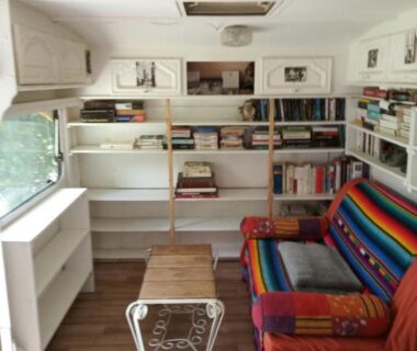 Intérieur avec bibliothèque et fauteuil coloré dans les Hébergements bohêmes pleine nature