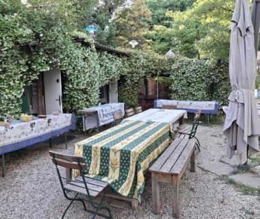 Cour extérieure avec grande table et bancs aux Hébergements bohêmes pleine nature