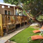 Terrasse en bois avec transats dans le jardin du mobil-home HerGine