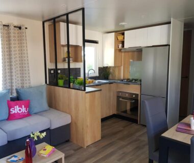 Séjour avec kitchenette et canapé dans le mobil-home au camping HerGine
