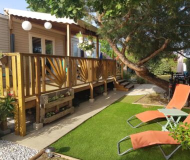 Terrasse en bois avec transats dans le jardin du mobil-home HerGine