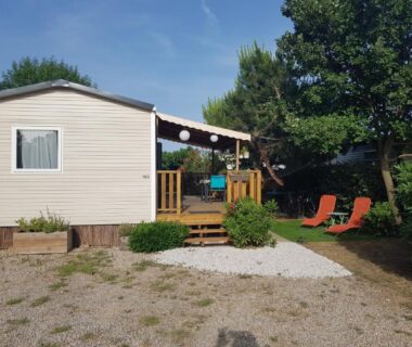 Terrasse en bois avec chaises longues et mobil home du camping HerGine
