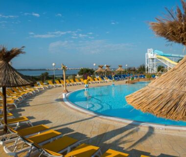 Piscine extérieure avec toboggan et parasols au camping HerGine