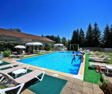 Piscine extérieure avec transats et parasols à l'Hôtellerie de Plein Air Camping Leychoisier