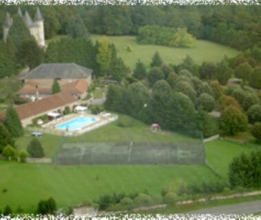 Piscine et terrains de tennis entourés d'arbres à l'Hôtellerie de Plein Air Camping Leychoisier