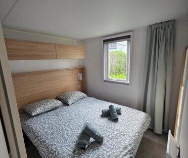 Chambre avec lit double et serviettes sur le lit dans le mobilhome Houlgate-154- Mobilhome cosy 4 personnes Camping 5 étoiles
