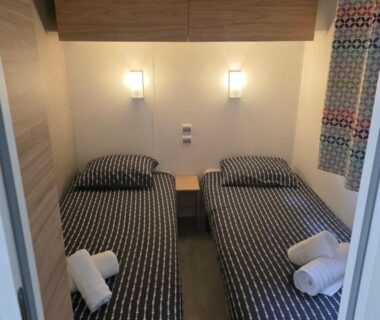 Chambre avec deux lits jumeaux et serviettes pliées dans le mobilhome Houlgate-154 Mobilhome cosy 4 personnes Camping 5 étoiles