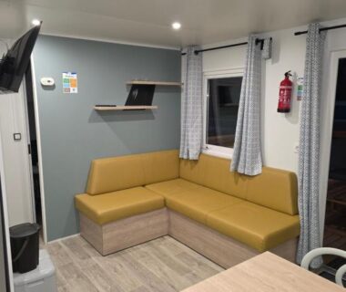 Séjour avec canapé d'angle moutarde dans le mobilhome Houlgate-206 Mobilhome Premium 6 personnes Camping 5 étoiles