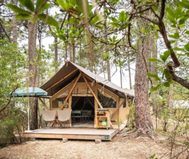 Terrasse en bois et tente safari sous les pins au camping Huttopia Arcachon