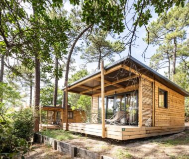 Terrasse en bois sous les pins avec chalet en bois au Huttopia Arcachon