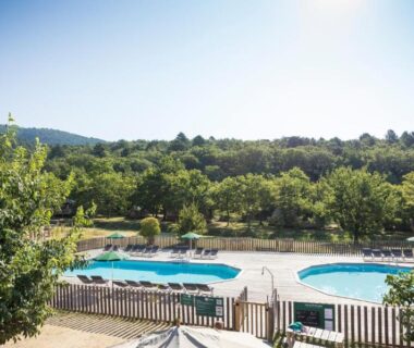 Piscine extérieure et bassins entourés de verdure au camping Huttopia Dieulefit
