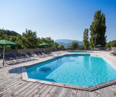 Piscine extérieure avec transats et parasols au camping Huttopia Dieulefit
