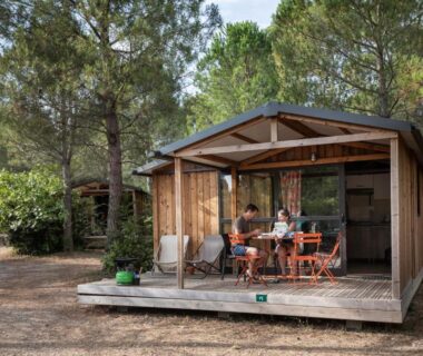 Terrasse en bois avec table et chaises dans le chalet Huttopia Fontvieille