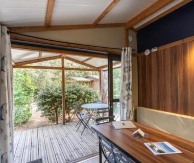 Terrasse en bois avec table et chaises au Huttopia Gorges du Tarn