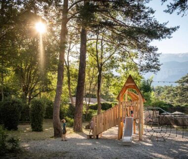 Aire de jeux en bois sous les pins au camping Huttopia Gorges du Verdon