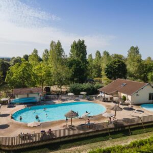 Piscine extérieure avec transats et parasols dans le camping Huttopia La Plage Blanche