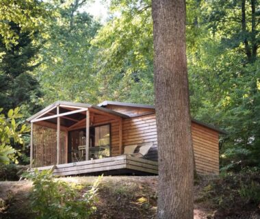 Dans la forêt chalet en bois sur terrasse au Huttopia Lac de Sillé