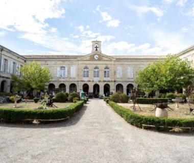 Cour centrale avec jardins et arcades du Huttopia Lac de l'Uby Gers