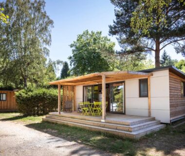 Terrasse en bois devant mobil-home au Huttopia Lac de la Siauve
