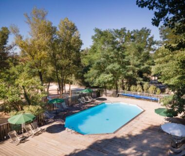 Piscine extérieure entourée d'arbres au camping Huttopia Le Moulin