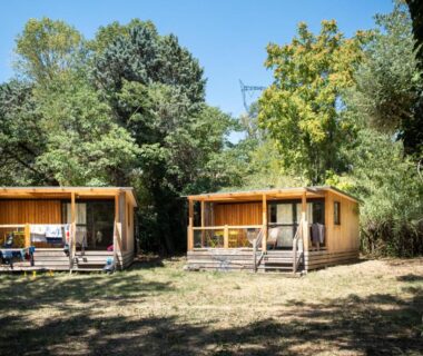 Clairière avec deux chalets en bois dans la nature au camping Huttopia Le Moulin